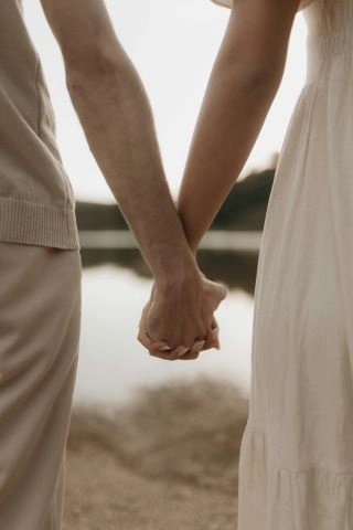 Couple holds hands together Couple holds hands together and watches the landscape.
